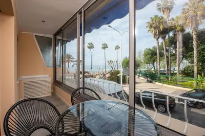 a balcony with a glass table and chairs and a view at Appartement Dollia - Welkeys in Cannes