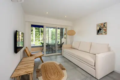 a living room with a couch and a table at Appartement Dollia - Welkeys in Cannes