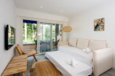 a living room with a white couch and a window at Appartement Dollia - Welkeys in Cannes