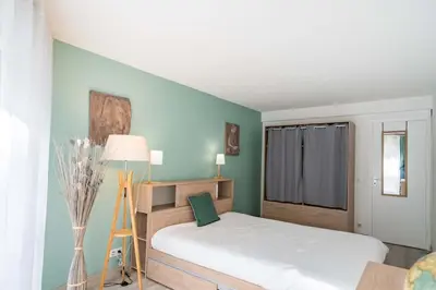 a bedroom with a white bed and a blue wall at Nice one bedroom in the heart of Cannes in Cannes