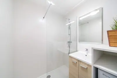 a white bathroom with a shower and a sink at Nice one bedroom in the heart of Cannes in Cannes