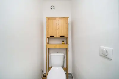 a bathroom with a toilet with a wooden cabinet at Nice one bedroom in the heart of Cannes in Cannes
