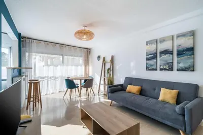 a living room with a blue couch and a table at Nice one bedroom in the heart of Cannes in Cannes