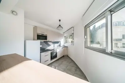 a kitchen with white appliances and a large window at Nice one bedroom in the heart of Cannes in Cannes