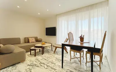 a living room with a table and a couch at Le charme de Cannes in Cannes