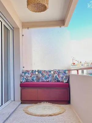 a red bench in a room with a window at Le charme de Cannes in Cannes