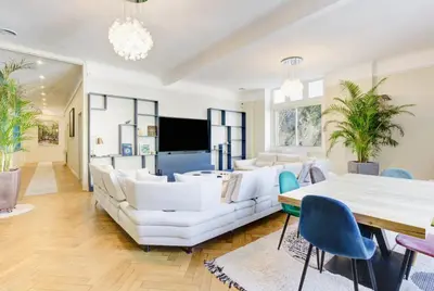 a living room with white furniture and a flat screen tv at Le Palais Beausite - Palais à Cannes in Cannes