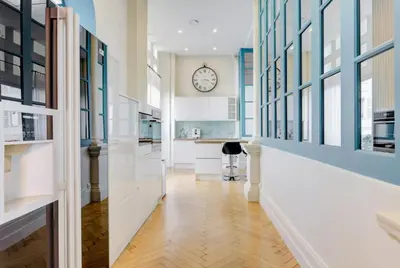 a hallway with a clock on the wall at Le Palais Beausite - Palais à Cannes in Cannes