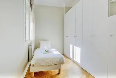 a white bedroom with a bed and a window at Le Palais Beausite - Palais à Cannes in Cannes