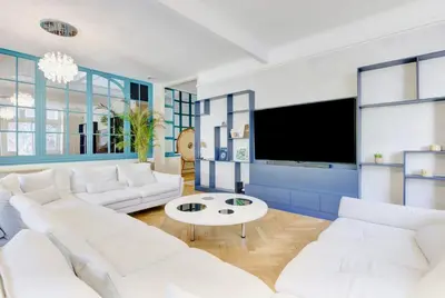 a living room with white furniture and a flat screen tv at Le Palais Beausite - Palais à Cannes in Cannes