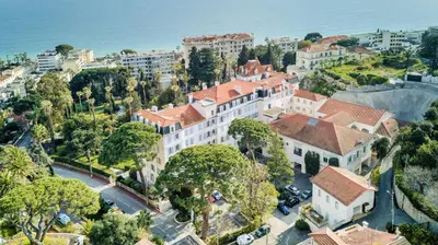 an aerial view of a large white building with red roofs at Le Palais Beausite - Palais à Cannes in Cannes