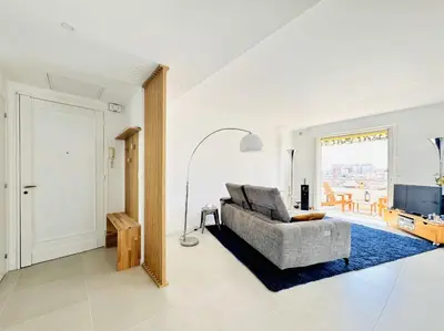 a living room with a couch and a television at L'impérator - Petit Juas Cannes in Cannes