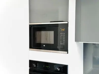 a microwave oven hanging on a wall in a kitchen at L'impérator - Petit Juas Cannes in Cannes