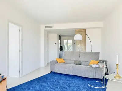 a living room with a gray couch and a blue rug at L'impérator - Petit Juas Cannes in Cannes