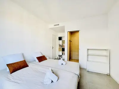 two beds in a bedroom with white walls at L'impérator - Petit Juas Cannes in Cannes