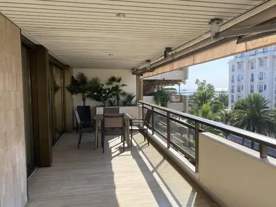 a balcony of a building with a table and chairs at Cannes Croisette - Appartement 3 Pièces Résidence GRAY D'ALBION in Cannes