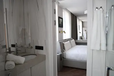 a white bathroom with a bed and a bath tub at Apartments in the heart of Cannes in Cannes