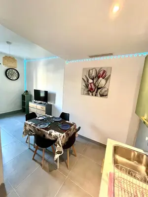 a dining room with a table and chairs in a room at Appartement 3 pièces GREEN ART **** in Le Cannet