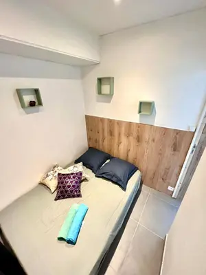 a small bed with two pillows on it in a room at Appartement 3 pièces GREEN ART **** in Le Cannet