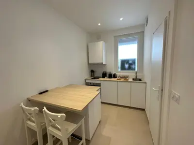 a kitchen with a wooden table and chairs in a room at C073-Studio neuf et lumineux au carre d'or Croisette in Cannes