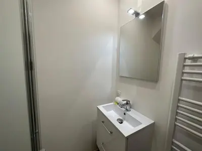 a white bathroom with a sink and a mirror at C073-Studio neuf et lumineux au carre d'or Croisette in Cannes