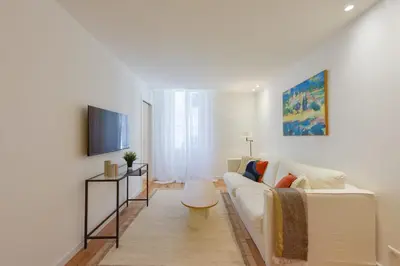 a living room with a white couch and a tv at Upscale 1-Br apartment 100 meter from the Palais des Festivals in Cannes