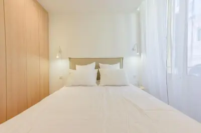 a bedroom with a large white bed with white pillows at Upscale 1-Br apartment 100 meter from the Palais des Festivals in Cannes