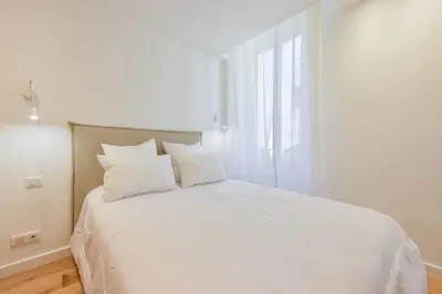 a white bed with white pillows in a bedroom at Upscale 1-Br apartment 100 meter from the Palais des Festivals in Cannes