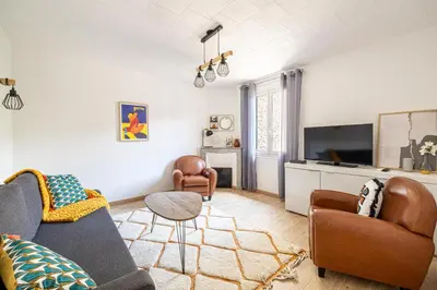 a living room with a couch and chairs and a tv at Beau 3 pièces à 500m du Palais des Festival in Cannes