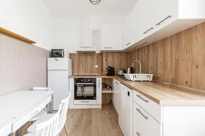 a kitchen with white appliances and wooden walls at Beau 3 pièces à 500m du Palais des Festival in Cannes