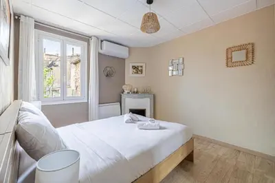 a bedroom with a white bed and a window at Beau 3 pièces à 500m du Palais des Festival in Cannes