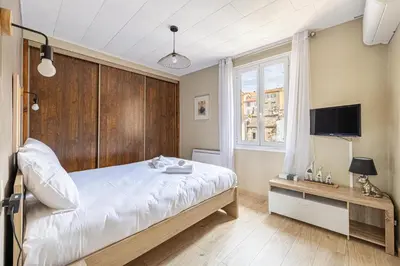 a bedroom with a large bed and a television at Beau 3 pièces à 500m du Palais des Festival in Cannes