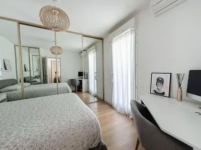 a bedroom with two beds and a mirror at Agencia Superbe appartement 2 chambres in Cannes