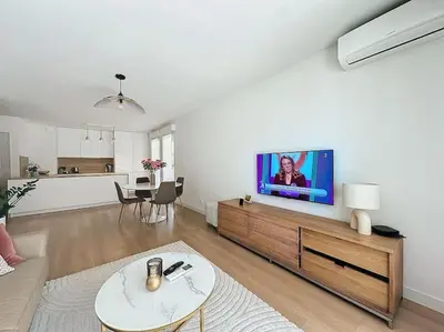 a living room with a flat screen tv on the wall at Agencia Superbe appartement 2 chambres in Cannes