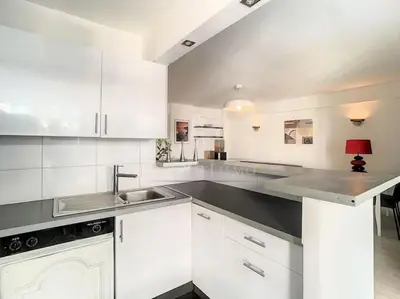 a kitchen with white cabinets and a sink at Grand 2 pieces- Marche Forville in Cannes