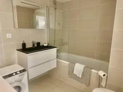 a white bathroom with a toilet and a sink at B035 Magnifique appartement neuf a deux pas du centre in Cannes