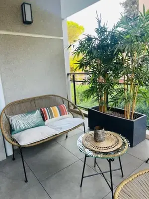 a patio with a couch and a table and plants at B035 Magnifique appartement neuf a deux pas du centre in Cannes