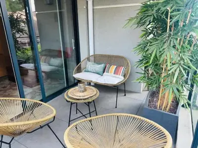 a patio with three chairs and a table with a pillow at B035 Magnifique appartement neuf a deux pas du centre in Cannes
