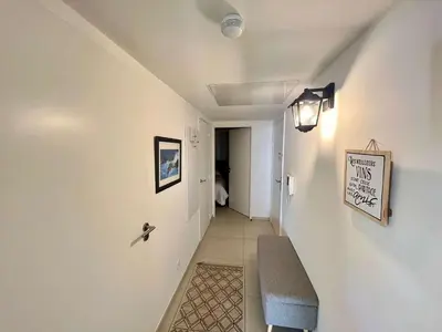 a hallway with a bench and a sign on a wall at B035 Magnifique appartement neuf a deux pas du centre in Cannes