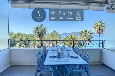 a table on a balcony with a view of the ocean at Le Croisette - 4 pers - Front de mer - 15 min Palais in Cannes