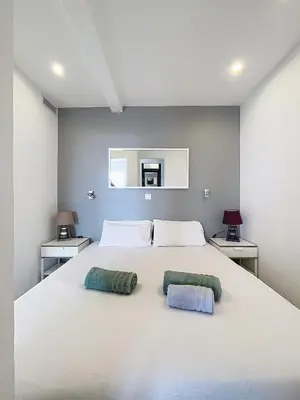 a bedroom with a large white bed with two pillows at Le Croisette - 4 pers - Front de mer - 15 min Palais in Cannes