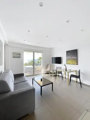 a living room with a couch and a table at Le Croisette - 4 pers - Front de mer - 15 min Palais in Cannes