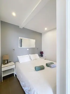 a bedroom with a white bed with two pillows on it at Le Croisette - 4 pers - Front de mer - 15 min Palais in Cannes
