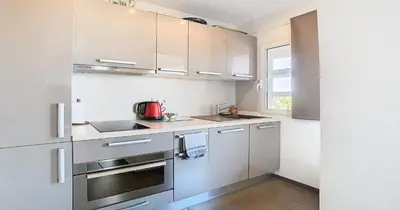 a kitchen with white cabinets and stainless steel appliances at Le Croisette - 4 pers - Front de mer - 15 min Palais in Cannes