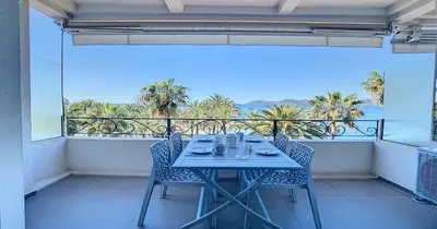 a table on a balcony with a view of the ocean at Le Croisette - 4 pers - Front de mer - 15 min Palais in Cannes