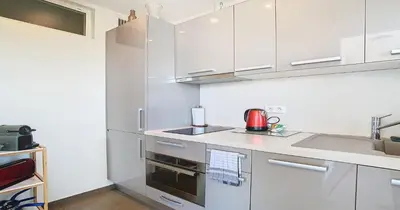 a kitchen with white cabinets and a stove top oven at Le Croisette - 4 pers - Front de mer - 15 min Palais in Cannes