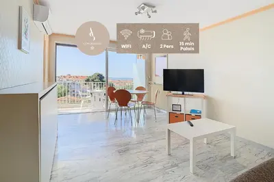 a living room with a table and a tv at Le Montfleury - Studio 28m2 - Vue mer - Centre in Cannes
