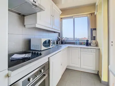a kitchen with white cabinets and a microwave at Le Montfleury - Studio 28m2 - Vue mer - Centre in Cannes