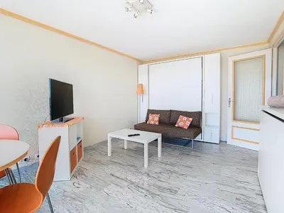 a living room with a couch and a tv at Le Montfleury - Studio 28m2 - Vue mer - Centre in Cannes