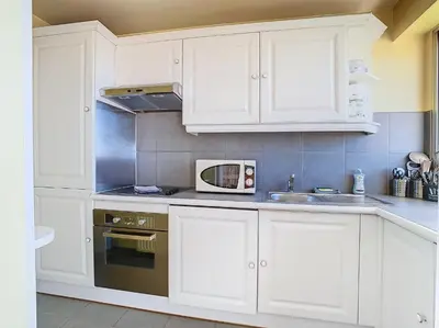 a kitchen with white cabinets and a microwave at Le Montfleury - Studio 28m2 - Vue mer - Centre in Cannes